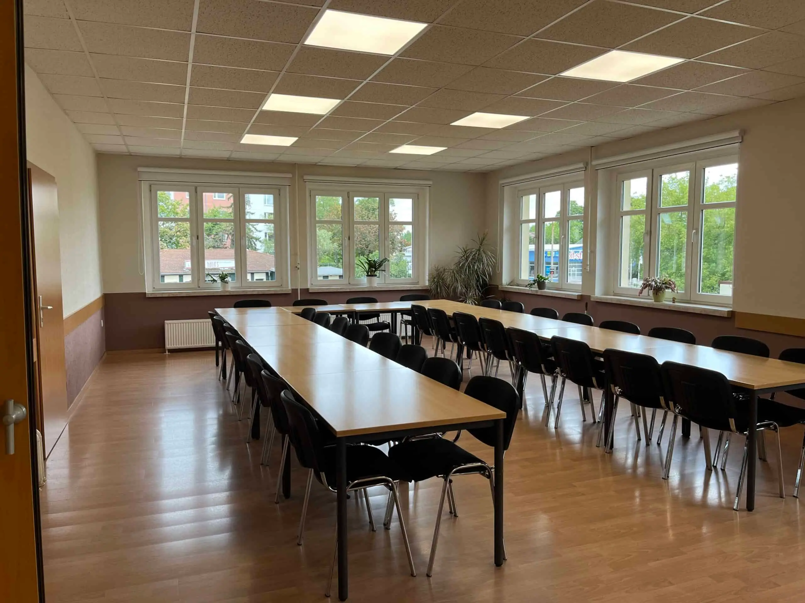 Der Saal des Schachraums mit langer Tafel in U-Form, Stühlen und Fenstern zu zwei Seiten